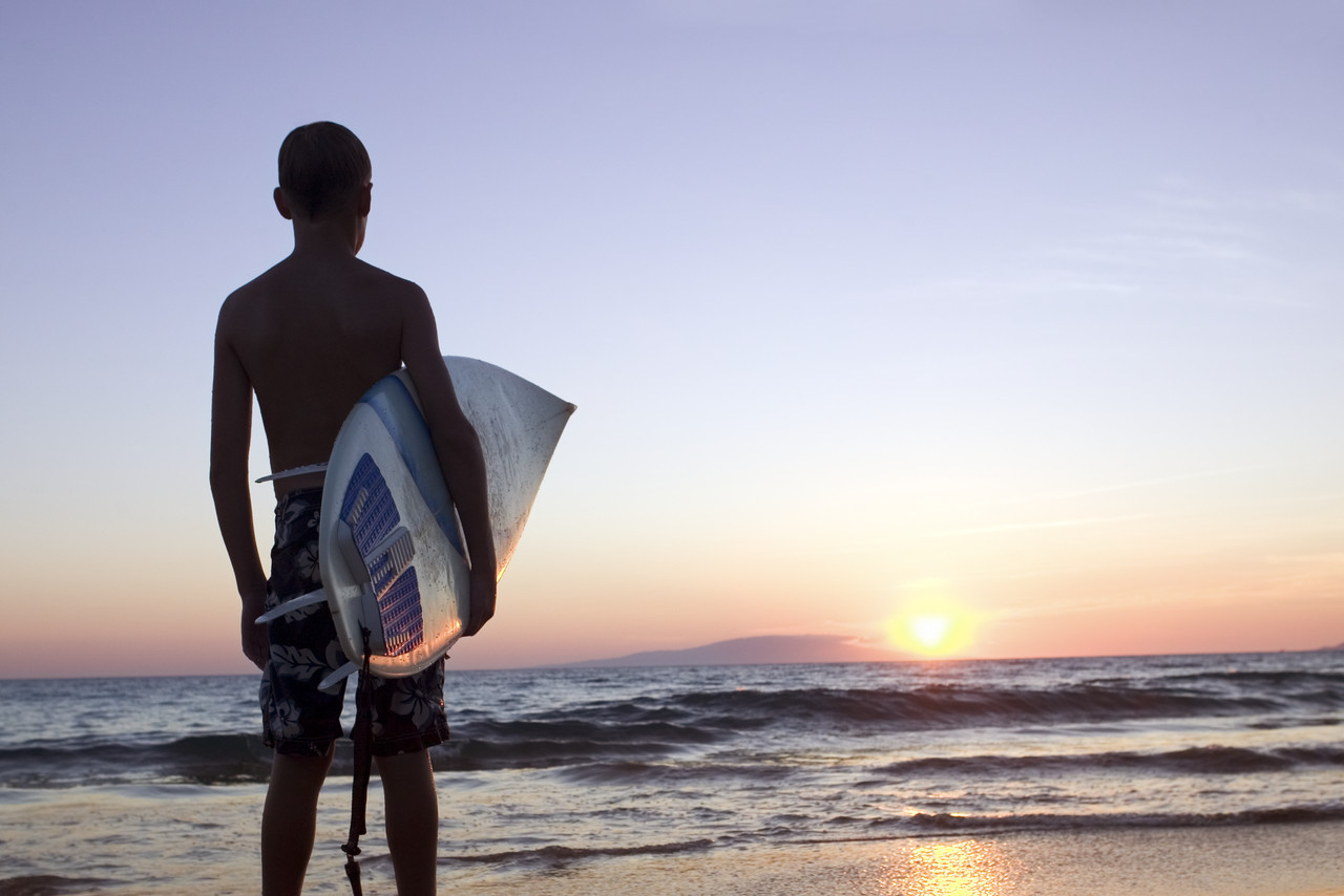 Surfer Holding Surfboard at Sunset